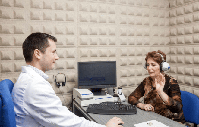 An audiologist at Hearing Health Connection shows their patient in Pennsylvania how to complete their hearing test.